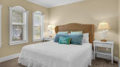 a bedroom with a white bed with blue pillows at Villas at Seagrove B101 in Santa Rosa Beach