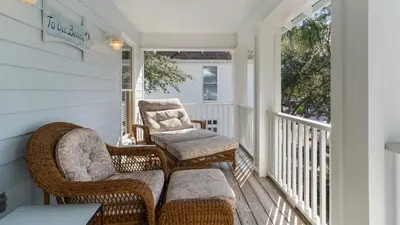 a porch with wicker chairs and a couch at The Ocean Pearl in Santa Rosa Beach
