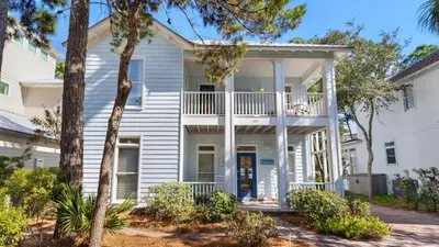 a white house with trees in front of it at The Ocean Pearl in Santa Rosa Beach
