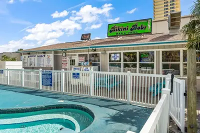 a restaurant with a pool in front of a building at The Summit 518 in Panama City Beach
