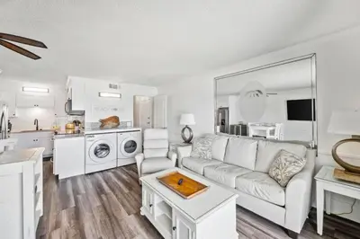 a living room with a couch and a kitchen at The Summit 518 in Panama City Beach