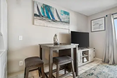 a room with a table with two stools and a television at The Summit 725 in Panama City Beach