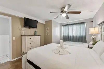 a bedroom with a white bed and a ceiling fan at The Summit 725 in Panama City Beach
