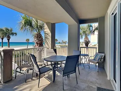 a balcony with a table and chairs and the beach at Grand Panama Beach Resort - The Grand #201 - Sunny Shores in Panama City Beach