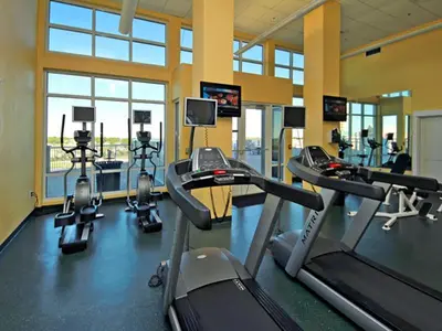 a gym with treadmills and cardio machines in a room at Grand Panama Beach Resort - The Grand #201 - Sunny Shores in Panama City Beach