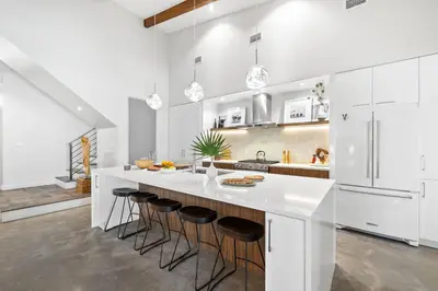 a white kitchen with a large island with bar stools at NEW Listing! 4 BR/ 3.5 BA, SLEEPS 10, HEATED SALT WATER POOL in Seagrove Beach