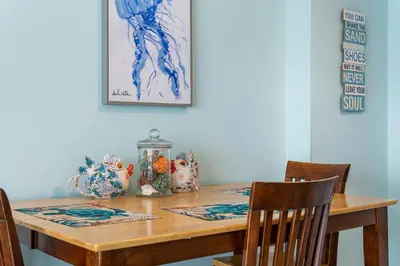 a dining room table with two chairs and a table with at Once Upon A Tide in Panama City Beach