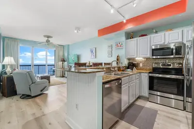 an open kitchen with a view of a living room at Once Upon A Tide in Panama City Beach