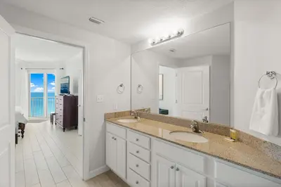 a bathroom with two sinks and a large mirror at Spectacular 3BD Beachfront Condo! Spacious! by Dolce Vita Getaways PCB in Panama City Beach