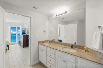a bathroom with two sinks and a large mirror at Spectacular 3BD Beachfront Condo! Spacious! by Dolce Vita Getaways PCB in Panama City Beach