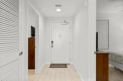 a white hallway with a door leading to a bedroom at Spectacular 3BD Beachfront Condo! Spacious! by Dolce Vita Getaways PCB in Panama City Beach