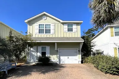a white house with a garage and a driveway at Grayling Beach House in Inlet Beach