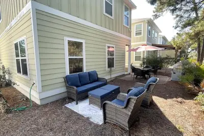 a patio with chairs and a table and a house at Grayling Beach House in Inlet Beach