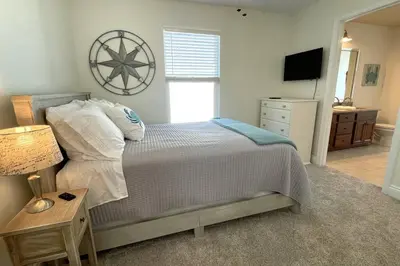 a bedroom with a bed and a dresser and a television at Grayling Beach House in Inlet Beach