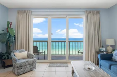 a living room with a view of the ocean at Seychelles #703 by Nautical Properties in Panama City Beach