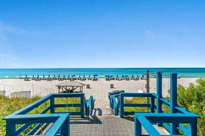 a group of blue benches on the beach at Seychelles #703 by Nautical Properties in Panama City Beach