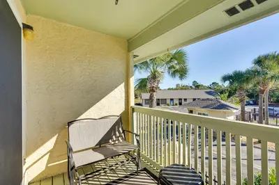 a balcony with a chair and palm trees at Walk to Beach and Restaurants PCB Resort Condo! in Panama City Beach