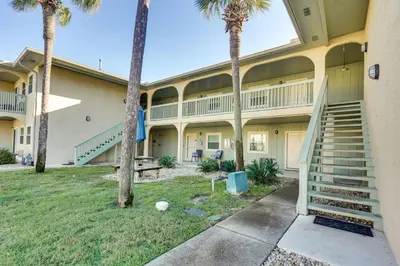 a large building with palm trees in front of it at Walk to Beach and Restaurants PCB Resort Condo! in Panama City Beach