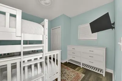 a bedroom with a bunk bed and a tv at Sterling Reef 1802B in Panama City Beach
