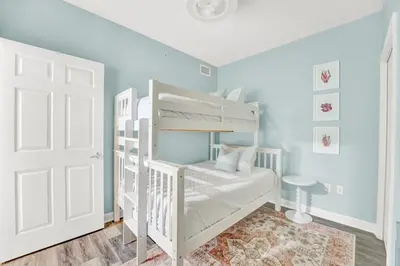 a bedroom with a white bunk bed and a white door at Sterling Reef 1802B in Panama City Beach