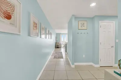 a hallway with blue walls and a tile floor at Sterling Reef 1802B in Panama City Beach