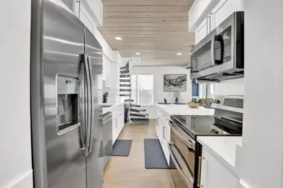 a large kitchen with a stainless steel refrigerator at Luxury Top-Floor Gulf-View Condo w/ Bunkroom & Balcony in Panama City Beach