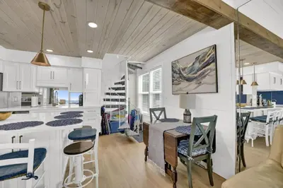 a kitchen and dining room with a table and chairs at Luxury Top-Floor Gulf-View Condo w/ Bunkroom & Balcony in Panama City Beach