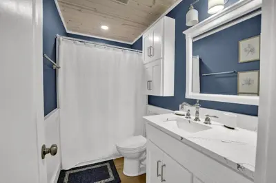 a bathroom with blue walls and a toilet and a sink at Luxury Top-Floor Gulf-View Condo w/ Bunkroom & Balcony in Panama City Beach