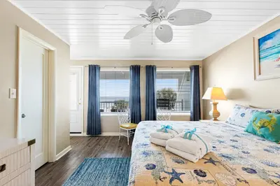 a bedroom with a bed with a ceiling fan at 3BR, 3BA beachfront townhome! Sleeps 11! Ocean view! Steps to the beach! in Panama City Beach