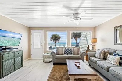 a living room with a couch and a tv at 3BR, 3BA beachfront townhome! Sleeps 11! Ocean view! Steps to the beach! in Panama City Beach