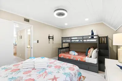 a bedroom with two bunk beds and a desk at 3BR, 3BA beachfront townhome! Sleeps 11! Ocean view! Steps to the beach! in Panama City Beach