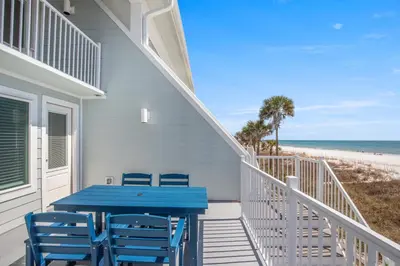 a blue table and chairs on a balcony with the beach at 3BR, 3BA beachfront townhome! Sleeps 11! Ocean view! Steps to the beach! in Panama City Beach
