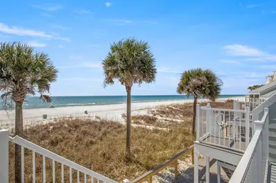 a staircase leading to the beach with palm trees at 3BR, 3BA beachfront townhome! Sleeps 11! Ocean view! Steps to the beach! in Panama City Beach