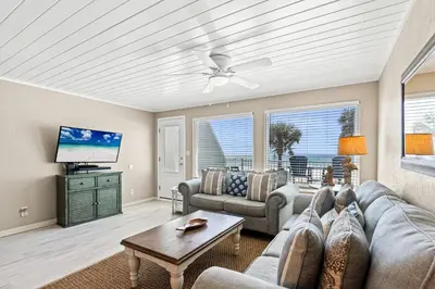 a living room with a couch and a tv at 3BR, 3BA beachfront townhome! Sleeps 11! Ocean view! Steps to the beach! in Panama City Beach