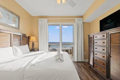 a bedroom with a large white bed and a window at Seychelles 205 in Panama City Beach