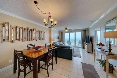 a dining room and living room with a table and chairs at Ocean Villa 1104 in Panama City Beach