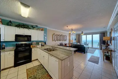 a kitchen and living room with a view of the ocean at Ocean Villa 1104 in Panama City Beach