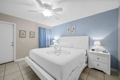 a bedroom with a white bed and a ceiling fan at 126 Seagrass Way in Panama City Beach