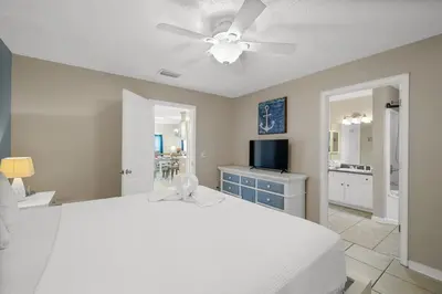 a bedroom with a white bed and a ceiling fan at 126 Seagrass Way in Panama City Beach