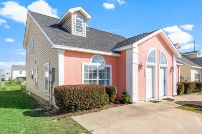 a pink house with a gray roof at 126 Seagrass Way in Panama City Beach