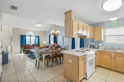 a kitchen and living room with a table and a dining room at 126 Seagrass Way in Panama City Beach
