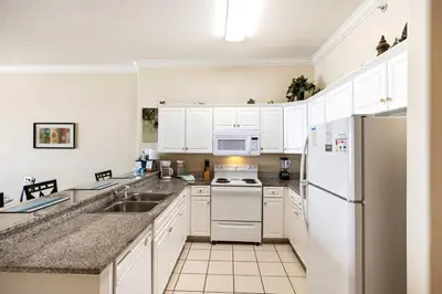 a kitchen with white appliances and white cabinets at Ocean Villa 2101 in Panama City Beach