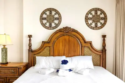 a bedroom with a wooden bed with two pillows at Ocean Villa 2101 in Panama City Beach