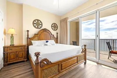 a bedroom with a large bed and a balcony at Ocean Villa 2101 in Panama City Beach