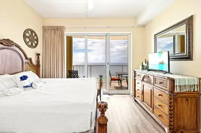 a bedroom with a large bed and a balcony at Ocean Villa 2101 in Panama City Beach