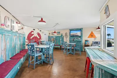 a restaurant with tables and chairs in a room at Top Of The Gulf 613 in Panama City Beach