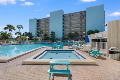 a swimming pool with blue chairs and a hotel at Top Of The Gulf 613 in Panama City Beach