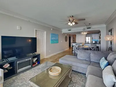 a living room with a couch and a flat screen tv at Majestic Beach Towers I #1503 in Panama City Beach