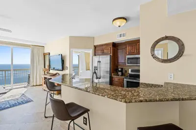 a kitchen with a counter and a view of the ocean at Emerald Coast Escapes in Panama City Beach