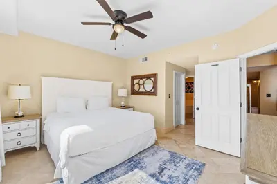 a bedroom with a white bed and a ceiling fan at Emerald Coast Escapes in Panama City Beach